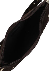 Bruine suède handtas met een ritssluiting. De binnenkant is van zwart stof, zonder zichtbare zakken of compartimenten.
