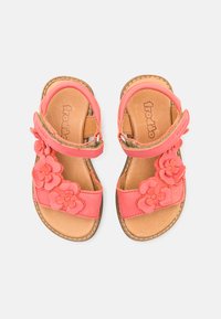 Korall lærsandaler med blomsterapplikasjoner, justerbare stropper, og en beige lærinnersåle. Flat såle med kontrastsøm detaljer.