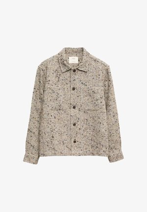 Veste chemise à motif chevron brun et crème avec un col, des boutons sur le devant et deux poches poitrine. Tissu texturé.