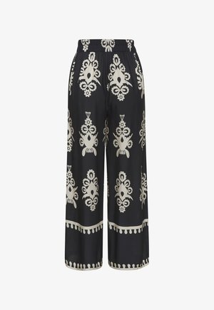 Black wide-leg pants featuring a light beige floral pattern, elastic waistband, and contrasting hem detail. Smooth fabric with a relaxed fit.