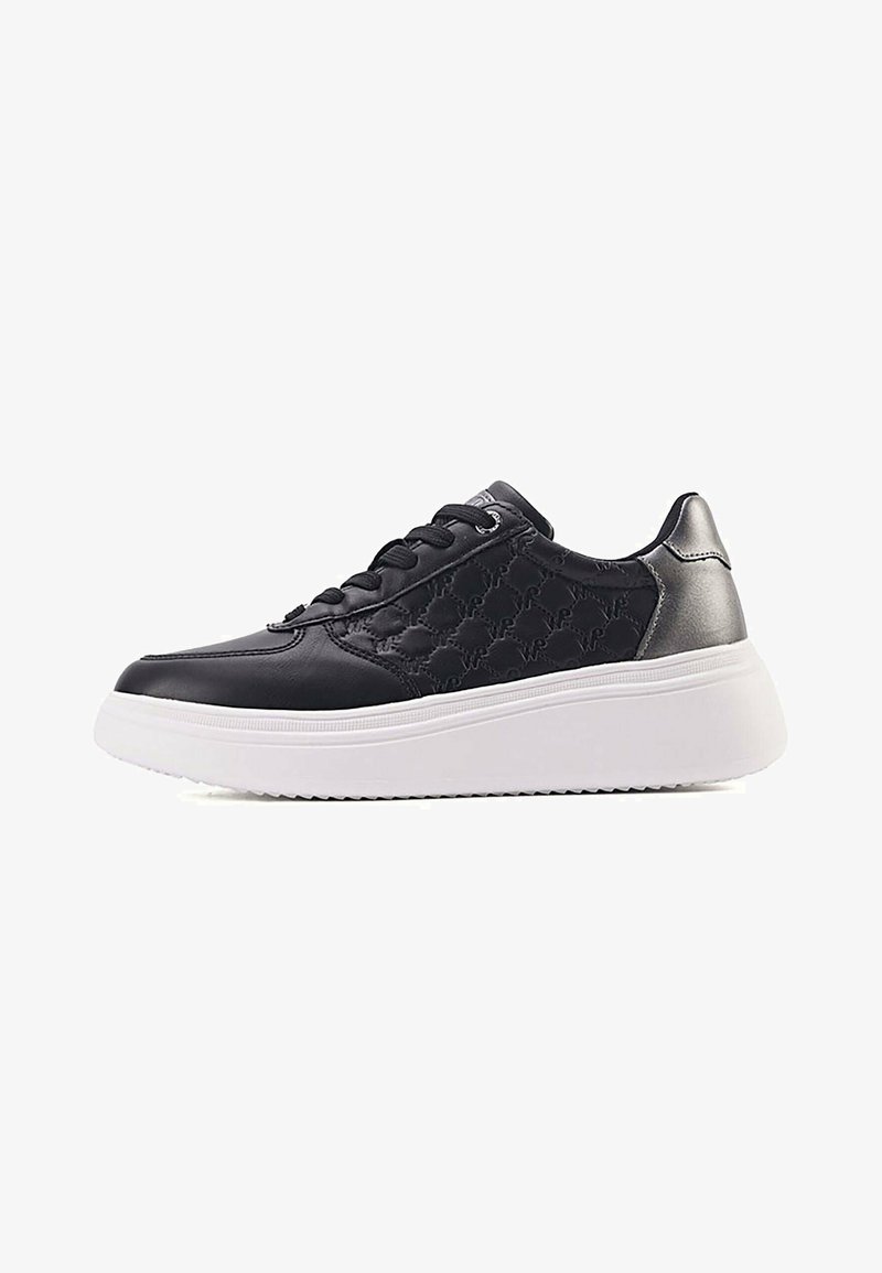 Musta sneaker, mis on valmistatud siledast ja tekstureeritud nahast, valge platvormi tallaga, paeltesed ja diskreetsete metalliliste detailidega.