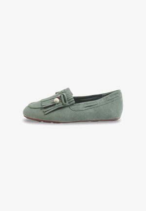 Mocassin plat en daim vert avec pompons et décoration de perles, bout rond et petit talon sur fond blanc.