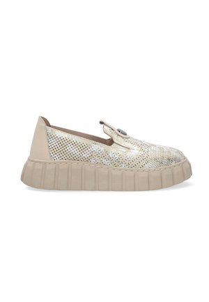 Beige slip-on shoe with a textured, perforated upper and thick, ridged sole. Features a decorative button on the side.