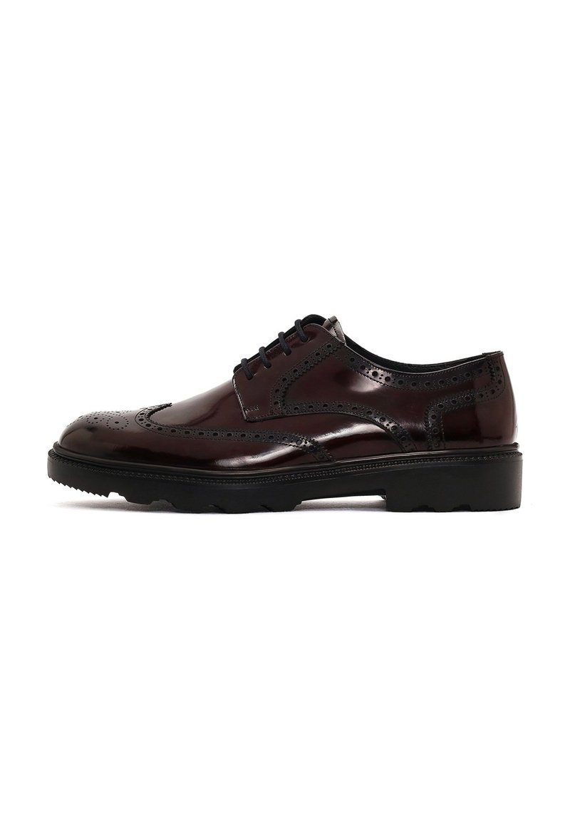 Zapato de vestir de cuero marrón con detalles de brogue, puntera redonda, suela de goma negra y cierre con cordones. Acabado suave y brillante.