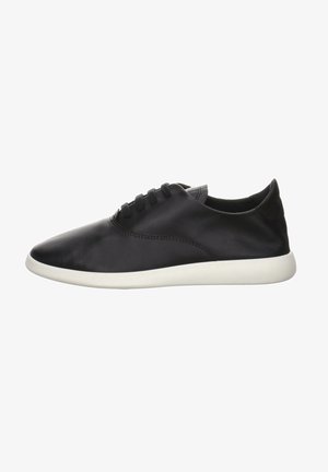 Czarny niskoprofilowy skórzany sneaker na sznurowadła z gładką cholewką i białą miękką podeszwą widziany z boku.