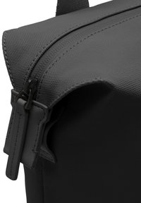 Sac noir texturé avec fermeture éclair, matériel résistant et coutures renforcées le long des bords pour plus de durabilité.