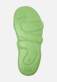 Green rubber sandal sole with a wavy design, marked with "Camper" logo and size "42". Smooth texture with rounded edges.