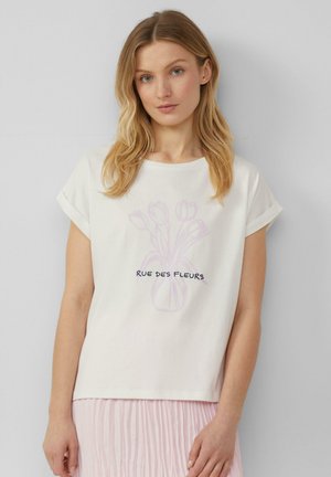 T-shirt en coton blanc avec des manches retroussées, présentant une illustration de tulipe rose pâle et le texte noir "RUE DES FLEURS" au centre.