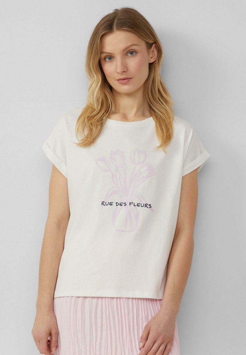 T-shirt en coton blanc avec des manches retroussées, présentant une illustration de tulipe rose pâle et le texte noir "RUE DES FLEURS" au centre.