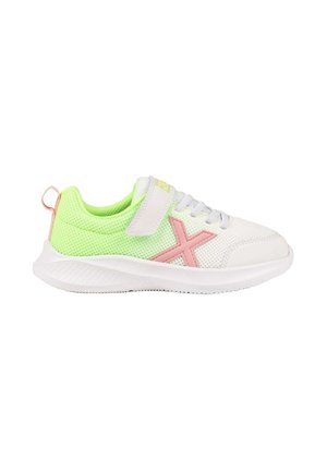Zapatilla blanca con malla verde neón, detalle en forma de X rosa, cordones blancos y una tira de velcro sobre un fondo blanco.