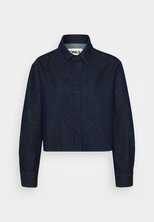 Dark blue denim shirt with a cropped design, featuring visible stitching and scattered light speckles, long sleeves, and a pointed collar.