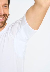 Hvid kortærmet t-shirt med en glat tekstur og rund kant. Har kontraststingdetaljer langs skuldrene og ærmerne.