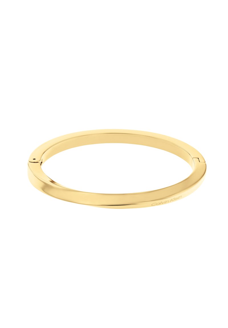 Kerge, poleeritud kullast bangle käevõru sujuva ümarate kujunditega ja peene brändimisega. Omab seametuks jäänud disaini ja minimalistlikku esteetikat.