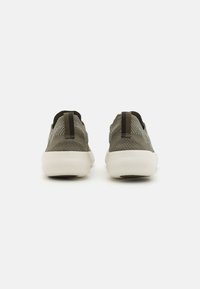 Sneaker in rete verde con suola in gomma bianca, caratterizzate da un design a taglio basso, tallone a linguetta e superficie testurizzata per la traspirabilità.