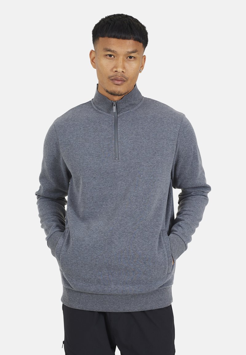 Felpa grigia con collo zip, maniche lunghe, polsini e orlo a costine, tessuto morbido, con tasca frontale e un design pulito e minimalista.
