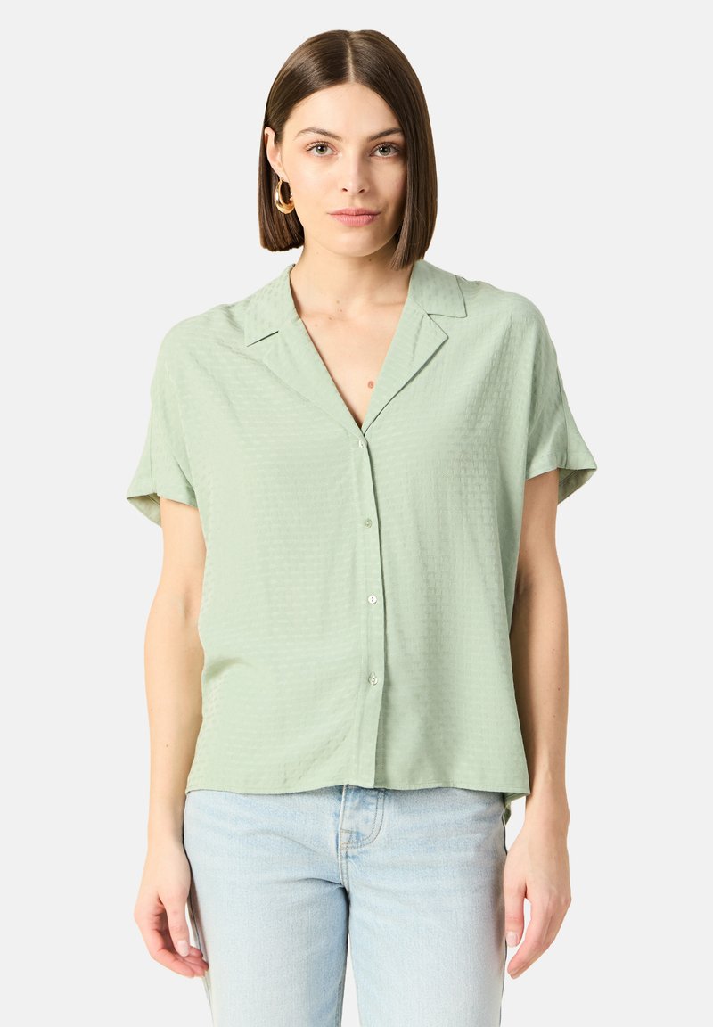 Lichtgroene blouse met korte mouwen, voorzien van een textuur patroon, knopen aan de voorkant en een ontspannen pasvorm, aangevuld met een notch kraag.