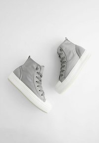 Gray high-top sneakers made of leather, featuring a white rubber sole, round toe, and metal eyelets for laces. Smooth texture and minimalist design.
