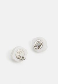 White plastic hair clips with a circular design, featuring silver metal clasps. Engraved text reads "Fiorucci Made in Italy."