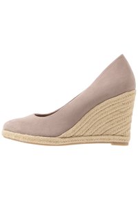 Scarpa con zeppa in suede beige chiaro con punta tonda e textura intrecciata simile al giute nel tacco, caratterizzata da una finitura liscia e linee pulite.