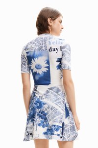 Dress with short sleeves, featuring a blue and white floral and graphic pattern, textured ribbed fabric, and a flared skirt design.