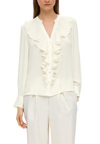 Weiße Bluse mit gerüschter Vorderseite, langen Ärmeln und Knopfschluss. Hergestellt aus glattem Stoff mit subtiler Textur und lockerer Passform.