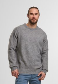 Maglione grigio lavorato a maglia con colletto rotondo, polsini e orlo a costine. Realizzato in tessuto morbido, presenta una vestibilità rilassata e un design minimalista.