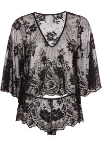 Set di lingerie in pizzo nero composto da un top con maniche a sbuffo e un perizoma abbinato. Il tessuto presenta motivi floreali e bordi ondulati.
