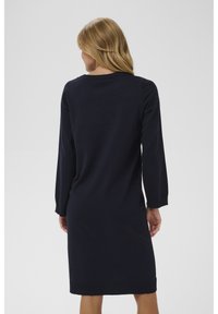 Robe tricotée bleu marine à manches longues, col rond et ourlet côtelé. Texture lisse avec une coupe classique et décontractée.