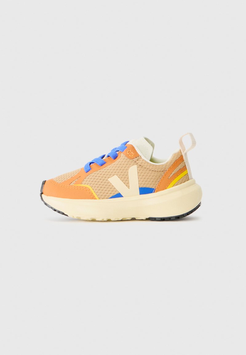 Tennised, millel on oranž võrkkangas ülemine osa, sinised paelad, kollased ja sinised aktsendid, kreemjas värvitoonis tallad ning kummine välistald haardes.