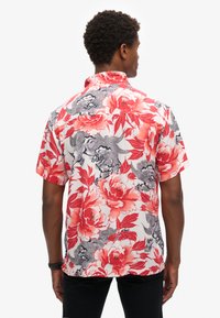 Kortekraagshirt met een bloemenprint in rood, roze en grijs op een witte achtergrond; beschikt over een klassieke kraag en een ontspannen pasvorm.