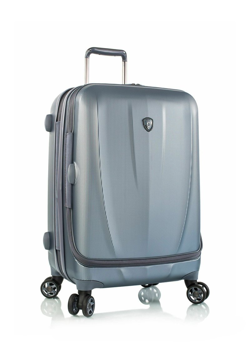 Silberner Hartschalenkoffer mit strukturierter Oberfläche, ausziehbarem Griff und vier doppelt drehenden Rollen für Stabilität und Manövrierbarkeit.