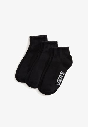 Tres pares de calcetines tobilleros negros con puños de canalé, un par con el logo blanco de Vans en el lateral.