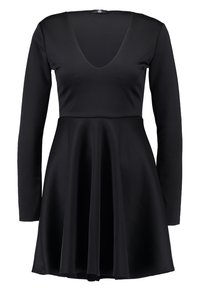 Musta pitkähihoinen mekko, jossa syvä V-pääntie, istuva yläosa ja levenevä helma. Valmistettu pehmeästä, joustavasta kankaasta. Helma ylettyy polven yläpuolelle.