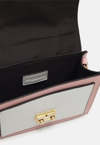 Lille håndtaske med en lyserød og grå læderoverflade, guld hardware og et satin sort interiør med et logo-tag.