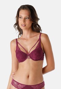 Reggiseno in pizzo borgogna con spalline doppie, caratterizzato da una lavorazione decorativa al centro. Coppe lisce e supportive con una sottile texture e un design floreale.