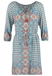 Robe bleu clair avec des motifs floraux et géométriques complexes en orange et blanc, manches 3/4, taille à nouer et encolure à nouettes avec pampilles.
