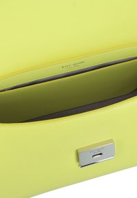 Borsa a mano gialla in pelle con una texture liscia, dotata di una chiusura in metallo argento e di un scomparto interno con rivestimento grigio.