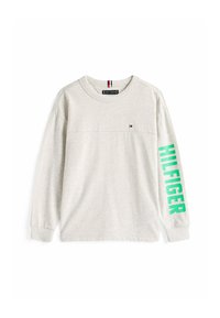Lysegrå langærmet skjorte med lille Tommy Hilfiger-flaglogo på brystet og lys grøn "HILFIGER" tekst på højre ærme.