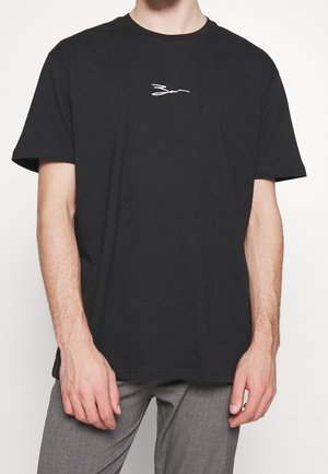 Černé bavlněné tričko s krátkými rukávy, které má na hrudi bílý vyšívaný podpisový logo. Volný střih a měkká textura.