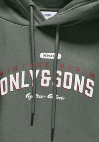 Zielona bluza z kapturem wykonana z miękkiego materiału, z grafiką z przodu z napisem "ONLY & SONS", "Vintage Denim" i "MMXII" w czerwonym i białym kolorze.