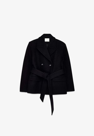 Juodos vilnos mišinio dvieilis paltas su dideliu atraižytu atlapu, diržu liemeniu ir dviem priekinėmis kišenėmis. Lygios tekstūros ir struktūruotos formos.