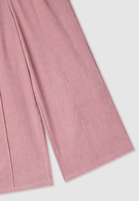 Tessuto di velluto a coste rosa con una finitura testurizzata, caratterizzato da gambe di pantaloni larghe e dritte e evidenti coste verticali in tutto il tessuto.