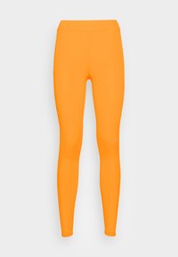 Orange leggings med hög midja, tillverkade av en mjuk och stretchig tyg, med en liten vit logotypdekoration nära ankeln.