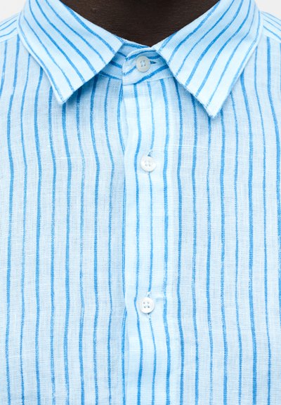 Close-up of a light blue and white vertically striped button-up shirt with a collar and three visible buttons fastened.