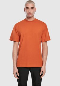 Korte mouwen t-shirt in diep oranje katoen. Relaxte pasvorm met een ronde hals en een gladde textuur. Eenvoudig ontwerp, geen patronen of graphics.