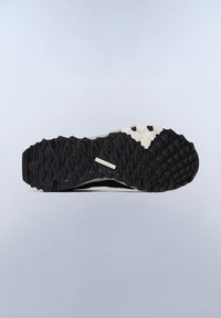 Suola di scarpa atletica robusta in bianco e nero con profonde scanalature per la trazione, caratterizzata da gomma testurizzata e una zona centrale liscia.