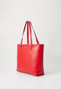 Borsa tote in pelle rossa con doppi manici, texture liscia, forma rettangolare e dettagli di cucitura visibili. Presenta un logo discreto sul davanti.