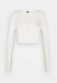 White cropped long-sleeve top made of soft fabric, featuring a round neckline and eight button closures along the front.