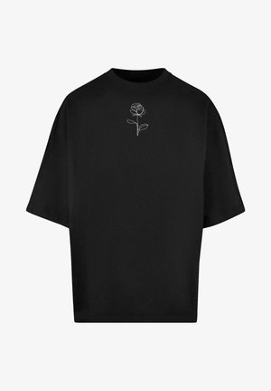 Black oversized t-shirt made of cotton, featuring a white outlined rose design on the chest, round neckline, and short sleeves.