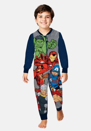 Pigiama a forma di onesie a tema supereroi con personaggi colorati stampati su un tessuto grigio e blu navy. Maniche lunghe, chiusura con zip e gambe a lunghezza intera.